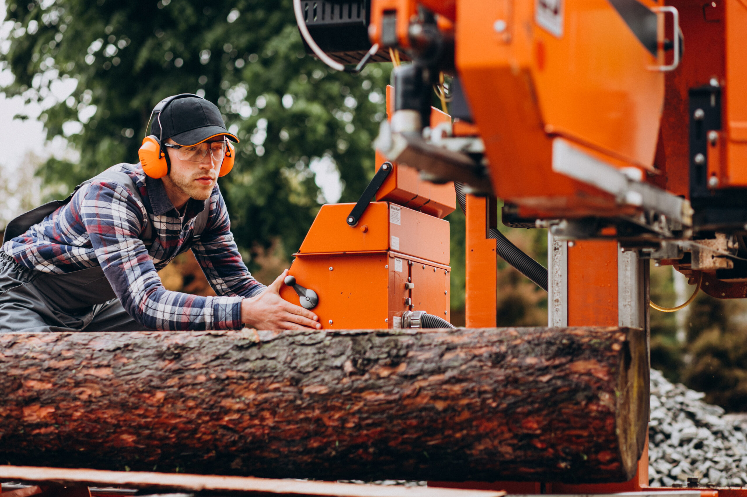 Carpenter working on a sawmill on a wood manufacture